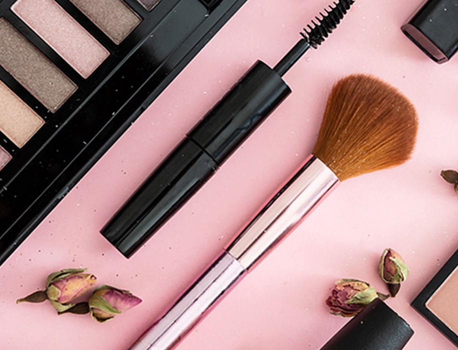 Viasun cosmetics with makeup brush and palette on pink background