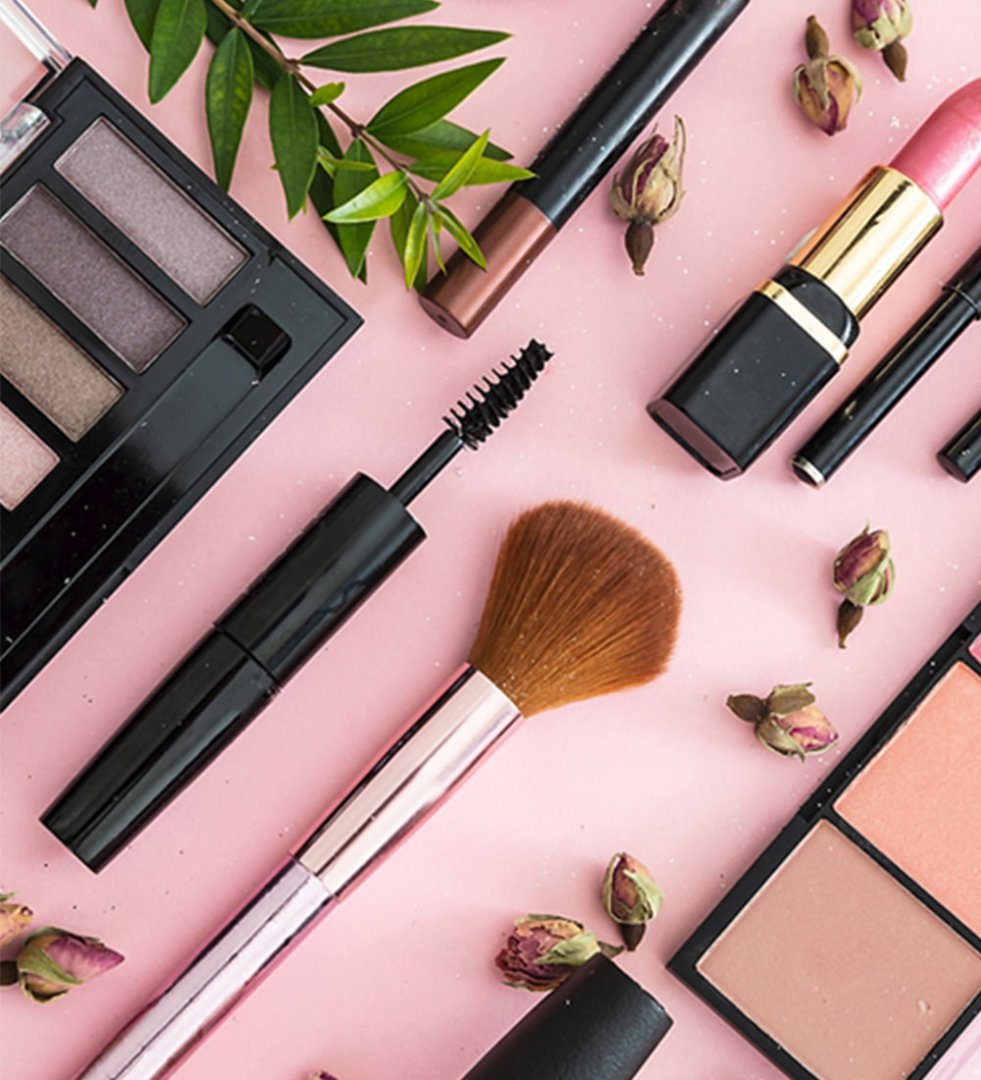 Viasun cosmetics displayed with makeup brushes and lipsticks on pink background.